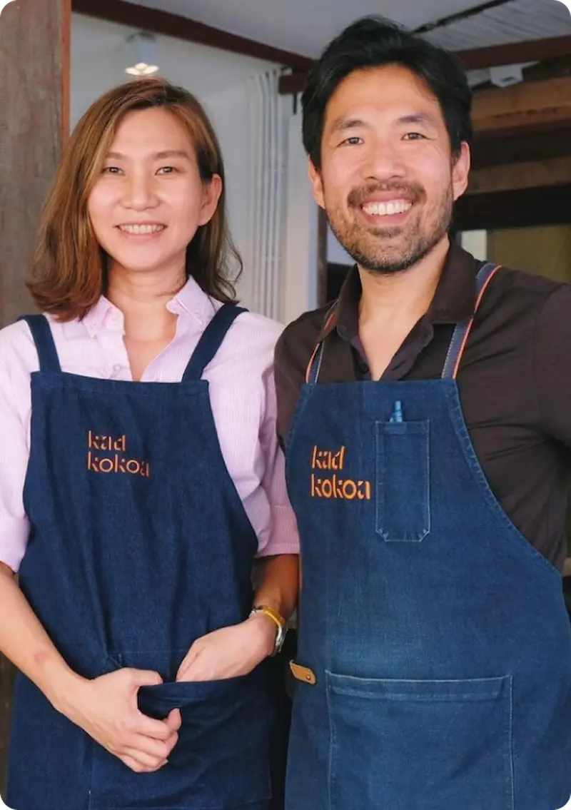 Kad Kokoa founders Paniti and Nuttaya wearing branded denim aprons